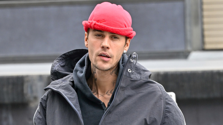 Justin Bieber walking around wearing a jacket and beanie