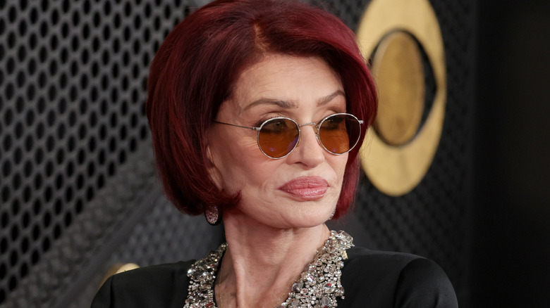 Sharon Osbourne poses at an event wearing sunglasses