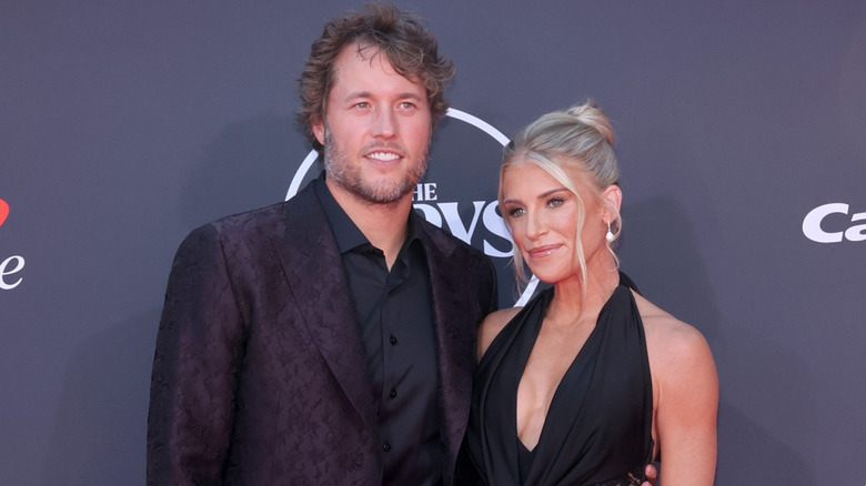 Matthew Stafford posing with his arm around Kelly Stafford.