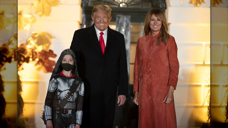Donald and Melania Trump posing with a kid