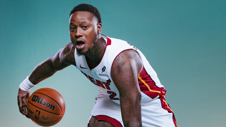 Terry Rozier posing for the Miami Heat with a basketball