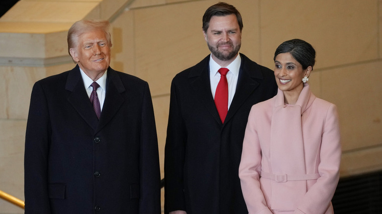 Usha Vance wears a pale pink coat and smiles next to JD and Donald Trump at the inauguration.